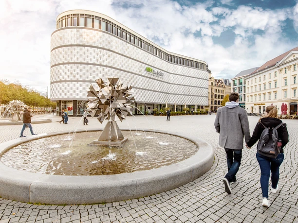 Widok na centrum handlowe Höfe am Brühl z Richard-Wagner-Platz z fontanną na pierwszym planie, rozrywka, zakupy, krótki odpoczynek