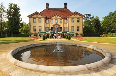 Schloss Schieder Renaissance-Schloss mit Springbrunnen im Vordergrund, umgeben von gepflegten Gartenanlagen.