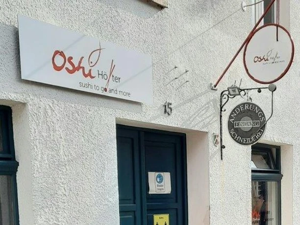 Eingang vom Restaurant Oshi mit Schild über der Tür
