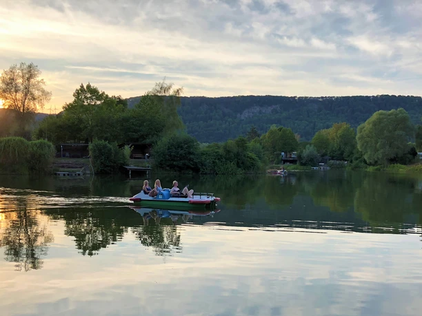 TretbootAbend_freizeitgelaene_ahlemeyer.jpg Tretboot mit Menschen auf dem See bei abendlichen Lichtverhältnissen