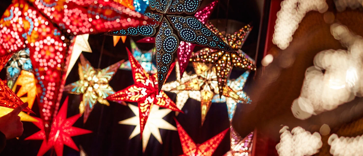 Bunte Deko-Sterne Farbenfrohe, leuchtende Sterne auf einem Weihnachtsmarkt im Kölner Stadtgarten.