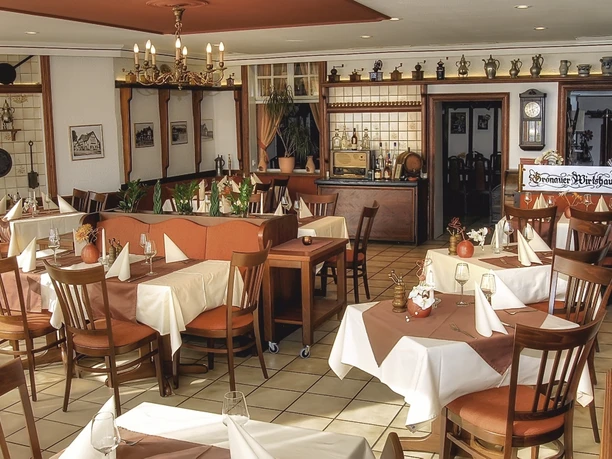 Restaurant Gemütliches Restaurant im rustikalen Stil mit Holzstühlen, gedeckten Tischen und dekorativem Interieur.