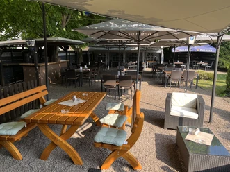 Biergarten Gemütlicher Biergarten mit Holzbänken und Sonnenschirmen, perfekt für entspannte Sommerabende.