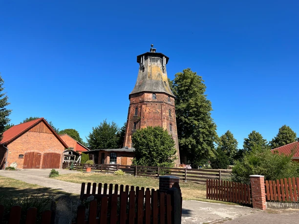 Mühle Hassel Historische Windmühle Hassel aus rotem Backstein, umgeben von Bäumen und blauen Himmel, in ländlicher Umgebung.