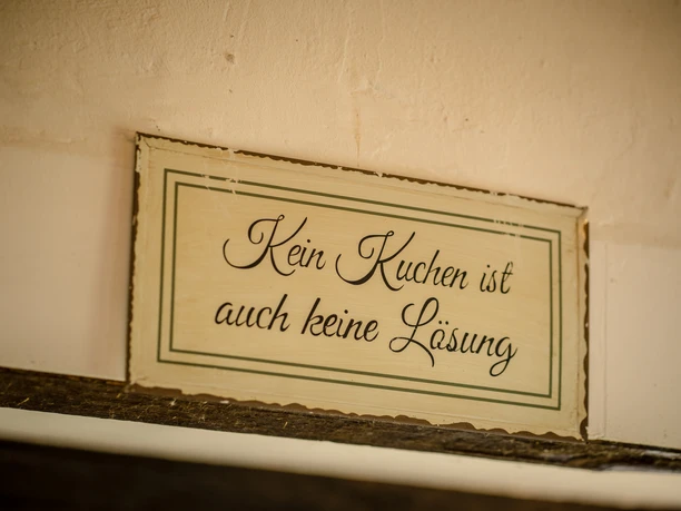 Café am Schloss, Dorsten Kein Kuchen ist auch keine Lösung - Charmantes Holzschild mit humorvollem Spruch an einer Wand.
