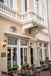 Charmantes Café im nostalgischen Stil mit einladender Terrasse und dekorativen Pflanzen.