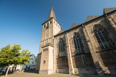 St. Lambertus Kirche in Mettmann Gotische Kirche mit spitzem Turm und neugotischen Fenstern unter blauem Himmel in Mettmann.