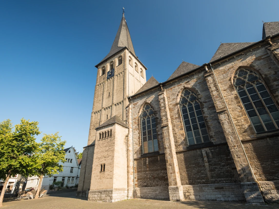 St. Lambertus Kirche in Mettmann Gotische Kirche mit spitzem Turm und neugotischen Fenstern unter blauem Himmel in Mettmann.