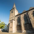 St. Lambertus Kirche in Mettmann Gotische Kirche mit spitzem Turm und neugotischen Fenstern unter blauem Himmel in Mettmann.