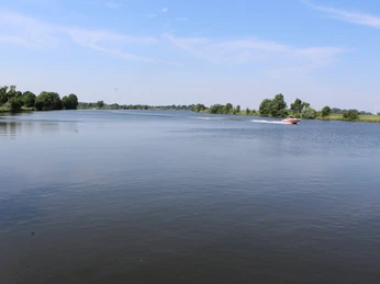 Dörverden Weser Weitläufiger Flusslauf der Weser bei Dörverden mit einem motorisierten Boot und grüner Uferlandschaft.Extensive course of the Weser near Dörverden with a motorized boat and green riverbank landscape.Wesers udstrakte forløb nær Dörverden med en motoriseret båd og et grønt flodlandskab.Uitgestrekte loop van de Weser bij Dörverden met een gemotoriseerde boot en groen oeverlandschap.