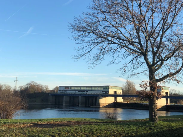 Wehr Schlüsselburg Schlüsselburg weir with tranquil river landscape in the sunshine, surrounded by bare trees in winter.