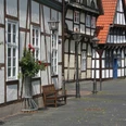 Altstadt Nienburg Fachwerkhäuser in Nienburg mit roten Dachziegeln, geschmückt mit Blumen und historischen Straßenlaternen.Half-timbered houses in Nienburg with red roof tiles, decorated with flowers and historic street lamps.Bindingsværkshuse i Nienburg med røde tagsten, udsmykket med blomster og historiske gadelamper.Vakwerkhuizen in Nienburg met rode dakpannen, versierd met bloemen en historische straatlantaarns.