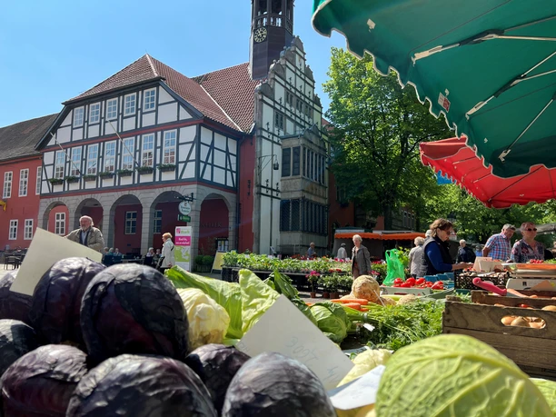 Wochenmarkt Nienburg Nienburg weekly market: fresh vegetables in front of a half-timbered building, market visitors enliven the scene.