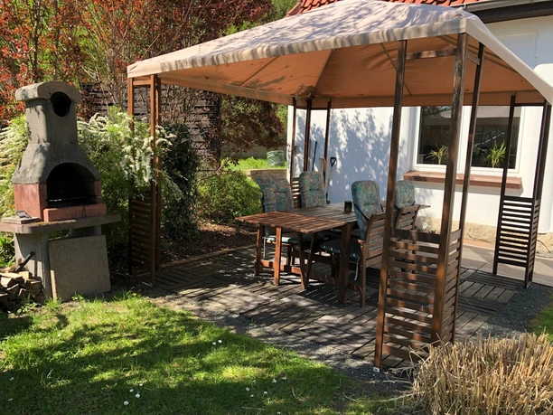 Die gemütliche Terrasse hinterm Haus lädt zum Grillen ein und gehört zu einer der Ferienwohnungen