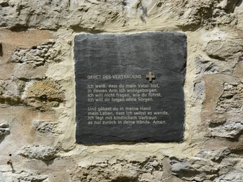 Pfarrkirche St. Michael Brakel Eine Gedenktafel mit dem Gebet des Vertrauens ist in eine alte, verwitterte Steinwand eingebettet.