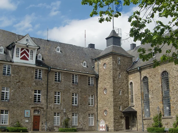 Schloss Hückeswagen Schloss Hückeswagen, historisches Gebäude mit Fachwerk und Turm, umgeben von grüner Vegetation.