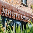 Moertelwerk - Gastronomie in Leipzig Blick auf die Backsteinfassade mit Schriftzug Moertelwerk, umrandet von Pflanzen, gastronomie, freisitz