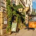 Noels Ballroom - Kneipen & Pubs in Leipzig Außenansicht des Noels Ballrooms und seine bewachsene Fassade, mit Schild und Straße im Hintergrund bei Sonnenschein