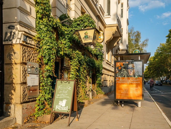 Noels Ballroom - Kneipen & Pubs in Leipzig Außenansicht des Noels Ballrooms und seine bewachsene Fassade, mit Schild und Straße im Hintergrund bei Sonnenschein