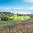 Golfclub Hösel in Heiligenhaus Golfplatz mit gepflegtem Grün und Bunkern, umgeben von Bäumen und einem Clubhaus im Hintergrund.