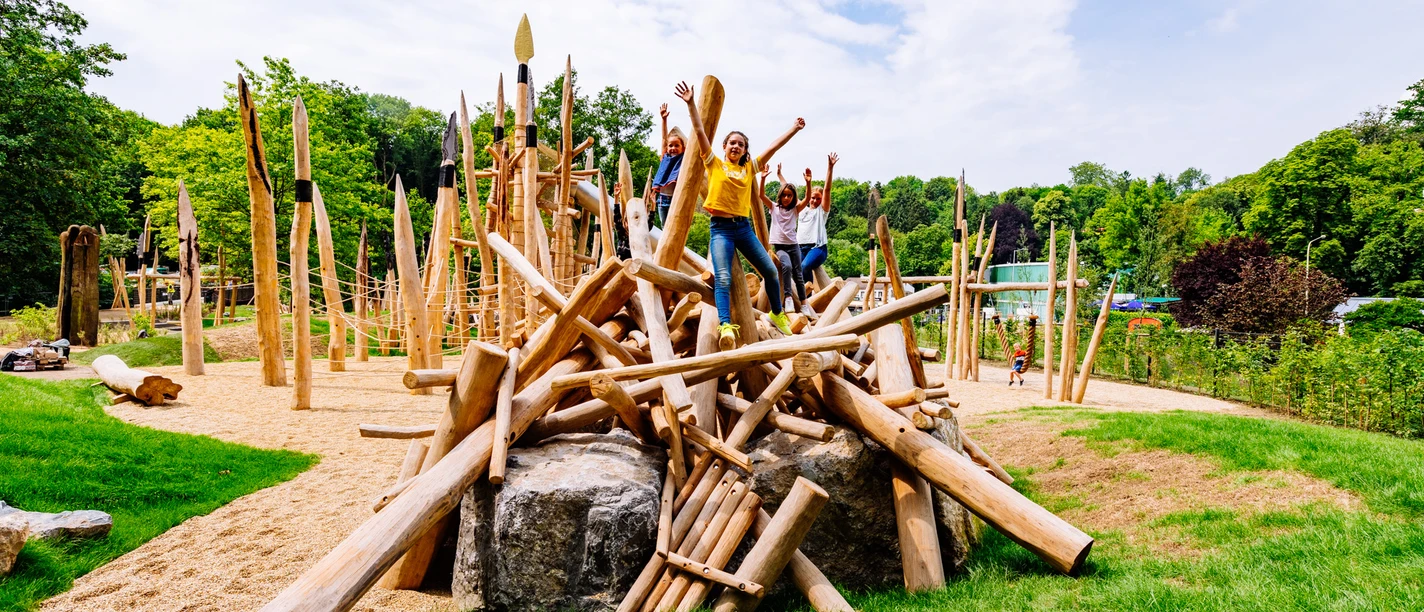 Steinzeitspielplatz am Neanderthal Museum in Mettmann Kinder spielen auf einem aus Holzstämmen gestalteten Abenteuer-Spielgerät im Freien.