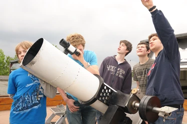 Observatorium der Sternwarte Neanderhöhe Hochdahl in Erkrath Eine Gruppe junger Menschen beobachtet durch ein großes Teleskop mit Begeisterung den Himmel.