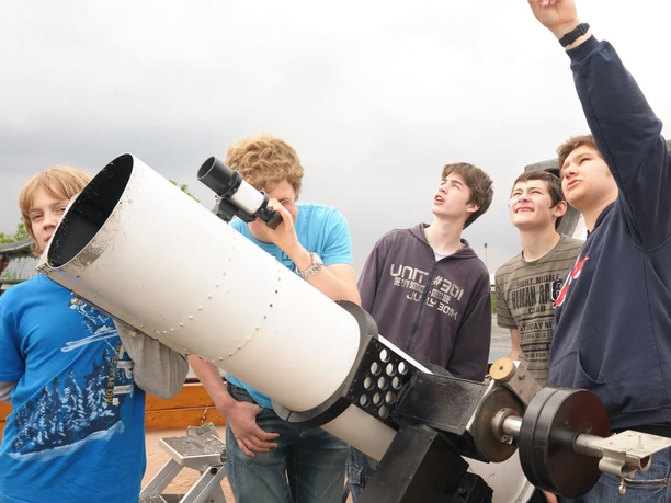 Observatorium der Sternwarte Neanderhöhe Hochdahl in Erkrath Eine Gruppe junger Menschen beobachtet durch ein großes Teleskop mit Begeisterung den Himmel.