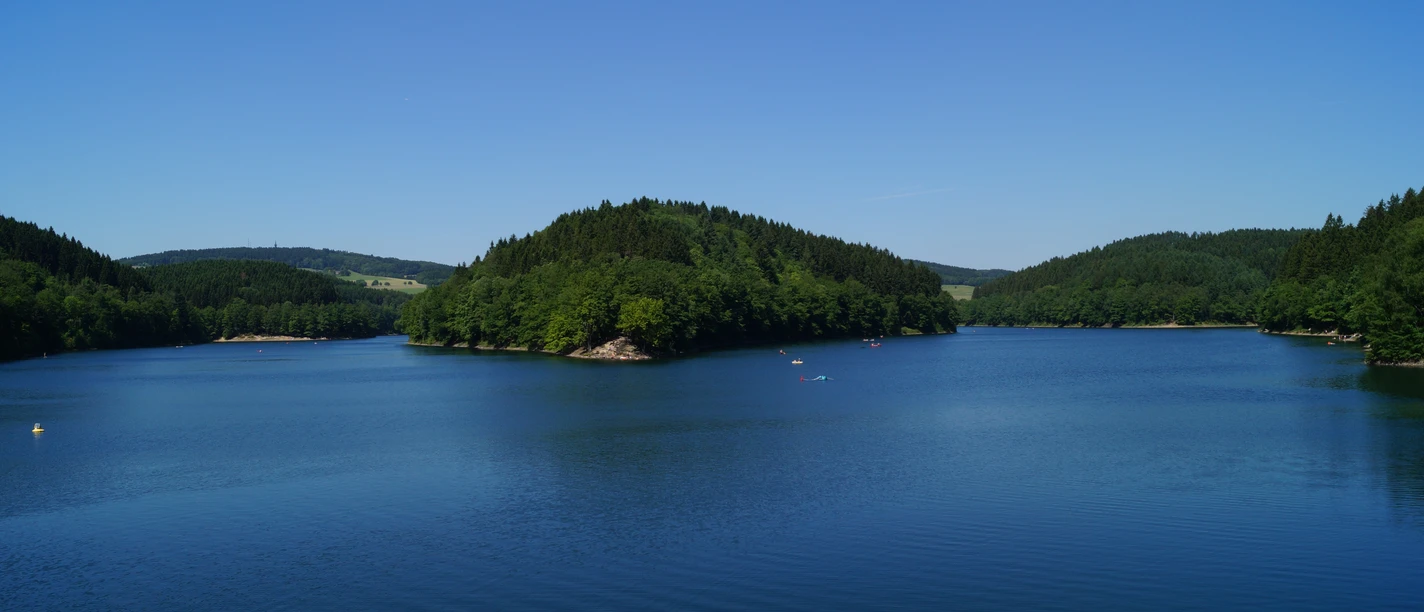 Aggertalsperre Ruheoase Bielsteinsperre bei Bergneustadt: Weitläufiger Stausee mit bewaldeten Ufern unter blauem Himmel.