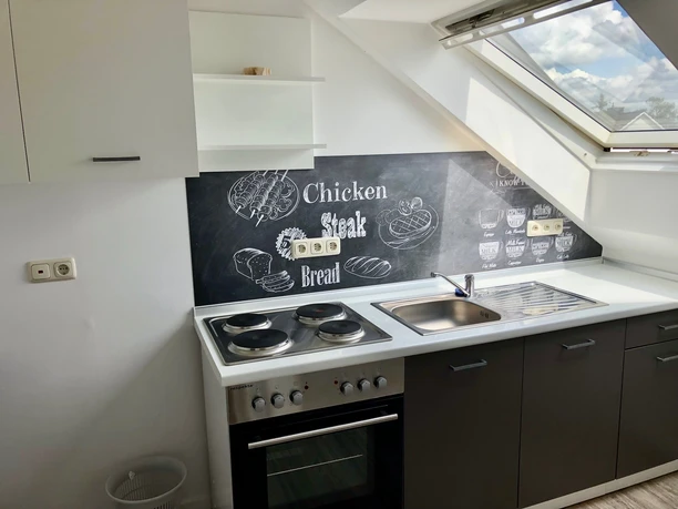 Moderne Küchenzeile mit Dachfenster und Kreidetafel-Dekor. Helle, freundliche Einrichtung.