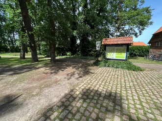 Wohnmobilstellplatz im Estorfer Scheunenviertel, eingebettet in eine grüne, baumbestandene Umgebung.