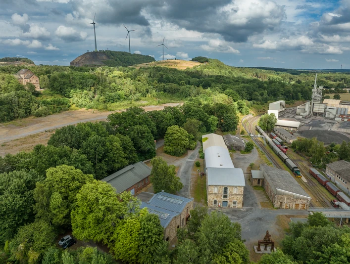 MIK am Piesberg in Osnabrück Industriegelände am grünen Piesberg, Osnabrück, mit Windkraftanlagen und historischer Architektur.Industrial site on the green Piesberg, Osnabrück, with wind turbines and historic architecture.Industriområde på det grønne Piesberg, Osnabrück, med vindmøller og historisk arkitektur.Industrieterrein op de groene Piesberg, Osnabrück, met windturbines en historische architectuur.