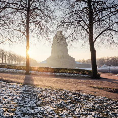 Východ slunce na zasněženém Völkerschlachtdenkmal, který je obklopen holými stromy, Volný čas, Zima, Kultura, Památka