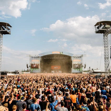 Many people stand in front of the Highfield's big stage and celebrate exuberantly, festival in Leipzig, city of music