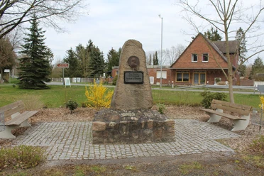 Gedenkstein Gründer von Lichtenhorst Gedenkstein in Lichtenhorst mit Büste und Inschrift, umgeben von Bänken und Landschaft.
