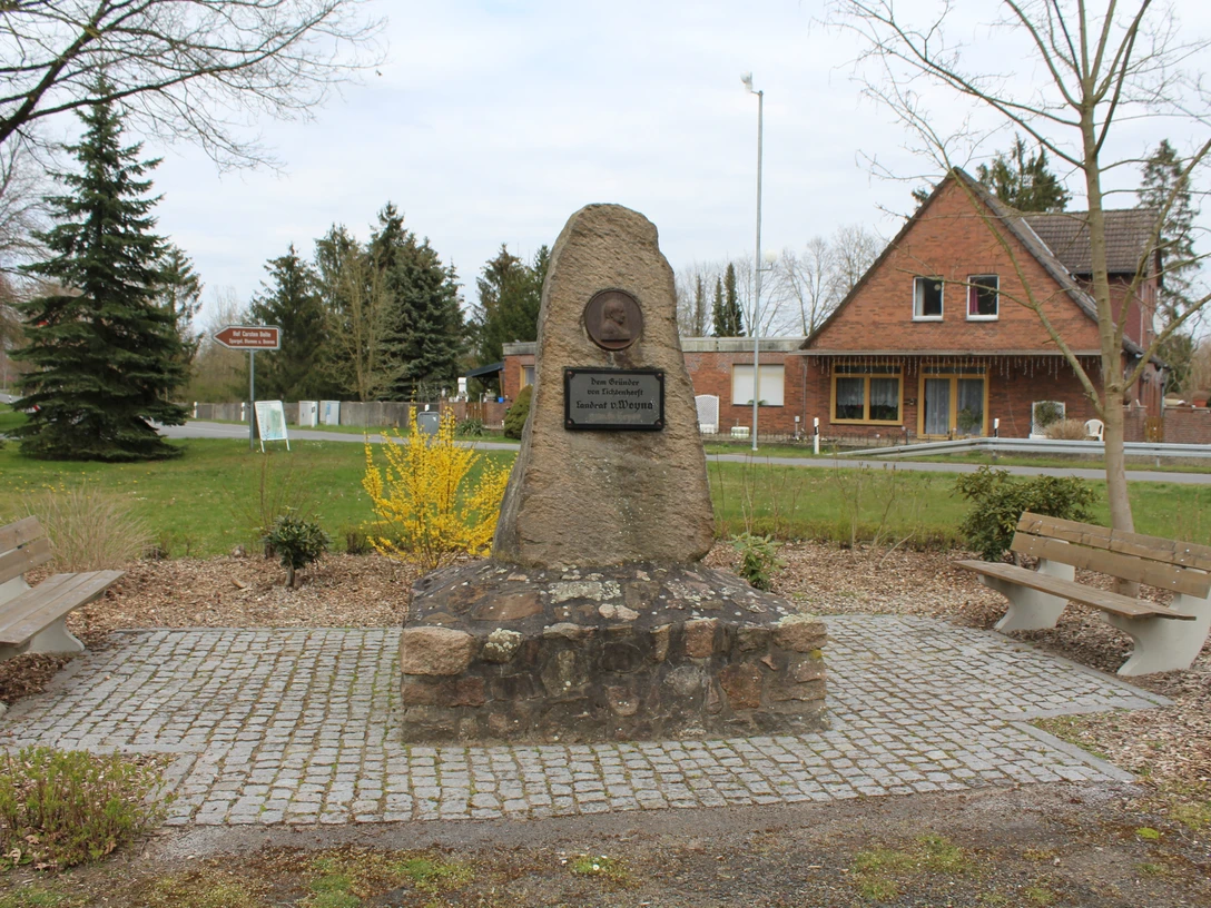Gedenkstein Gründer von Lichtenhorst Gedenkstein in Lichtenhorst mit Büste und Inschrift, umgeben von Bänken und Landschaft.