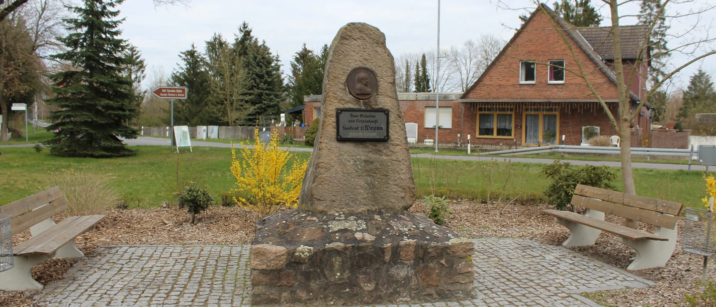 Gedenkstein Gründer von Lichtenhorst Gedenkstein in Lichtenhorst mit Büste und Inschrift, umgeben von Bänken und Landschaft.