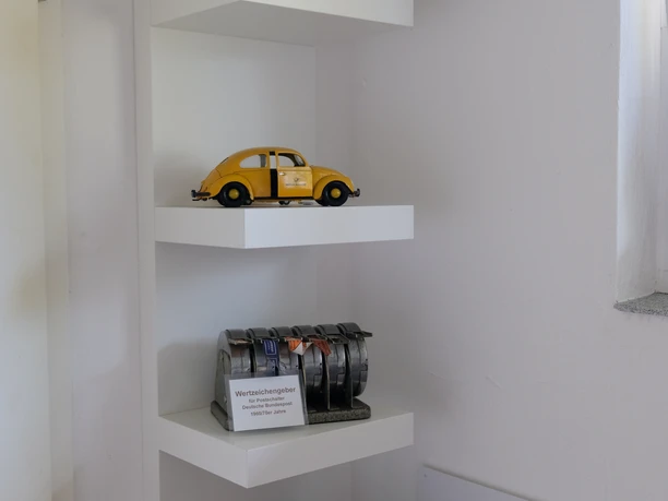 Postmuseum Bokel Ein detailreich dekoriertes Regal im Postmuseum Bokel zeigt Miniaturmodelle historischer Postfahrzeuge und -gebäude.