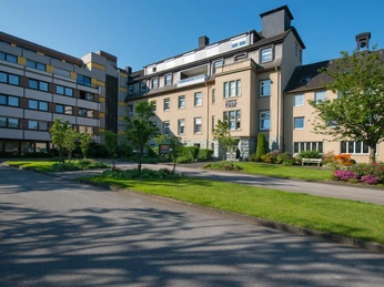 Missionshaus Neuenbeken Missionshaus Neuenbeken: Historisches mehrstöckiges Gebäude mit gepflegtem Vorgarten bei strahlendem Wetter.