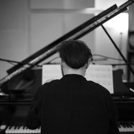 You can see the back view of Clemens sitting in front of a grand piano, Musikstadt Leipzig, grand piano