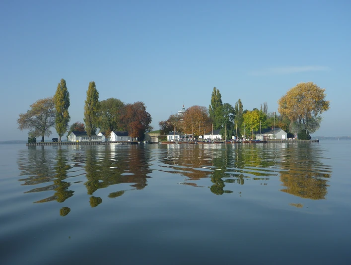 Insel Wilhelmstein Im klaren Wasser spiegeln sich herbstliche Bäume und historische Gebäude der Insel Wilhelmstein.Autumnal trees and historic buildings on the island of Wilhelmstein are reflected in the clear water.Det klare vand reflekterer efterårstræer og historiske bygninger på øen Wilhelmstein.Het heldere water weerspiegelt de herfstachtige bomen en historische gebouwen op het eiland Wilhelmstein.