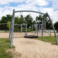 Spielplatz Am Sandbach in Ratingen Ein moderner Spielplatz mit Klettergerüsten und Schaukeln, umgeben von grünen Bäumen und Wiesen.