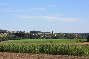 Lichtenau | Ortsansicht Blick auf das Dorf Lichtenau, eingebettet in grüne Felder und umgeben von sanften Hügeln.