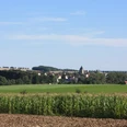 Lichtenau | Ortsansicht Blick auf das Dorf Lichtenau, eingebettet in grüne Felder und umgeben von sanften Hügeln.