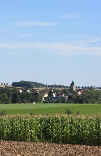 Lichtenau | Ortsansicht Blick auf das Dorf Lichtenau, eingebettet in grüne Felder und umgeben von sanften Hügeln.