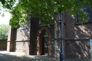 Marienkapelle in Monheim am Rhein Backsteinbau der Marienkapelle in Monheim am Rhein mit Spitzbogenportal und umgebender Straßenlaterne.