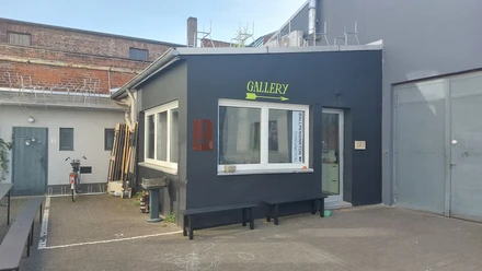 Arty Farty Ein moderner Galerieeingang mit dezenten Farben und klaren Linien in einem urbanen Umfeld.