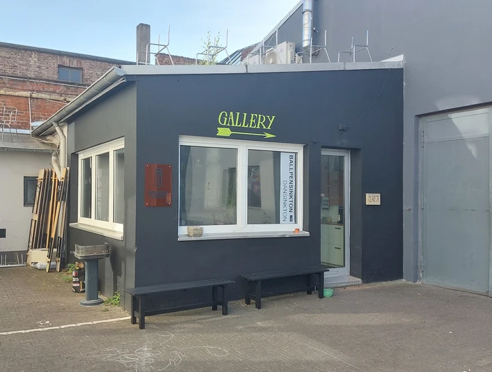 Arty Farty Ein moderner Galerieeingang mit dezenten Farben und klaren Linien in einem urbanen Umfeld.A modern gallery entrance with subtle colors and clean lines in an urban environment.