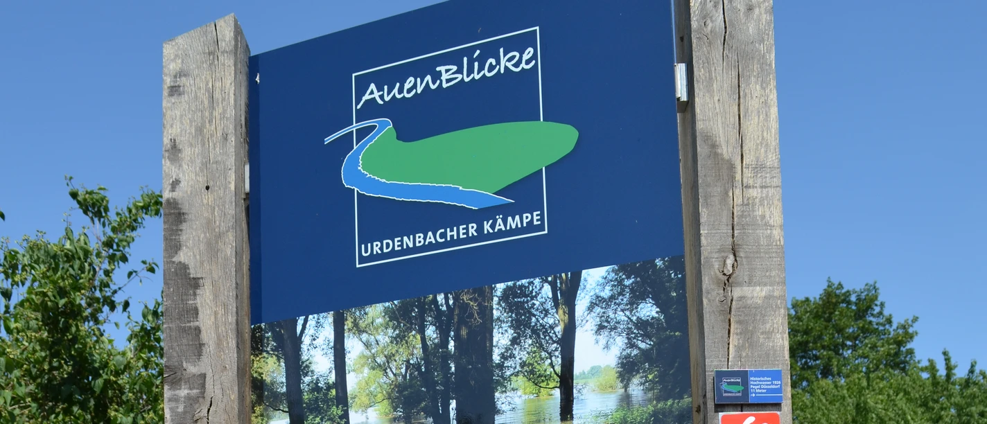 AuenBlicke: Wandern in der Urdenbacher Kämpe Ein Holzschild informiert über Wanderrouten und Sehenswürdigkeiten in der Urdenbacher Kämpe.