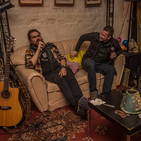 Two artists sit next to guitars on a couch in the Kulturlounge Leipzig, partying, dancing, clubs, celebrating.