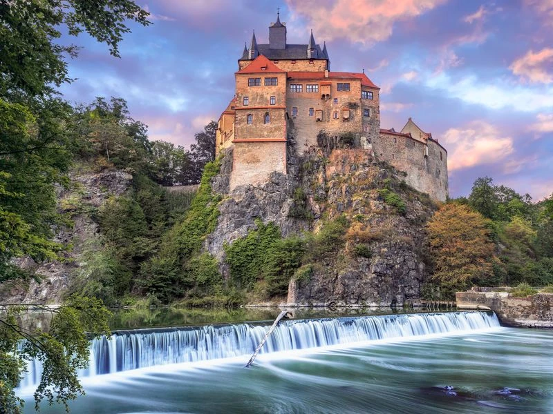 Burg-Kriebstein-Burgansicht-DDpix-Marcel-Quietzsch-800x600.jpg Burg Kriebstein thront malerisch auf einem steilen Felsen über einem Wasserfall in herbstlicher Umgebung.Kriebstein Castle sits picturesquely enthroned on a steep rock above a waterfall in an autumnal setting.Hrad Kriebstein se malebně tyčí na strmé skále nad vodopádem v podzimním prostředí.Zamek Kriebstein jest malowniczo położony na stromej skale nad wodospadem w jesiennym otoczeniu.Kasteel Kriebstein troont schilderachtig op een steile rots boven een waterval in een herfstachtige omgeving.Il castello di Kriebstein si trova pittorescamente in trono su una roccia scoscesa sopra una cascata in un ambiente autunnale.